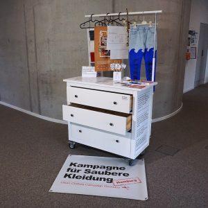 Eine weiße Kommode mit drei großen Schubladen steht vor einem grauen Hintergrund