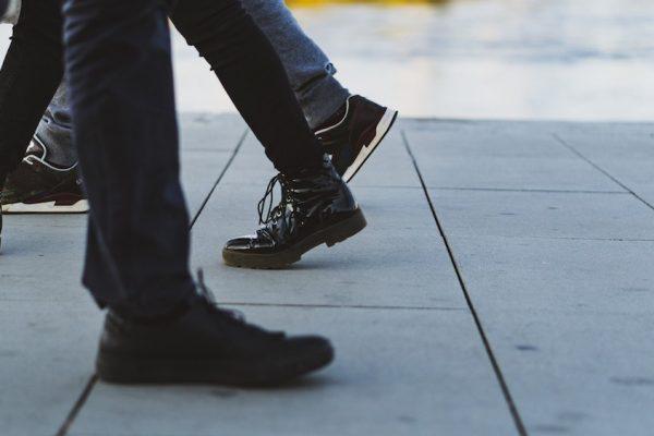 Stadtrundgang-Module zum Thema Baumwolle & Zwangsarbeit und Schuhe & Leder 7 Füße von Menschen, die über einen grauen Steinboden laufen