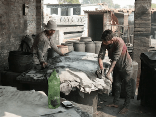 „Dreckiges Leder“: ein Filmangebot für die Faire Woche 2023 6 Screenshot des Films "Dreckiges Leder", im Hintergrund sind zwei Arbeiter in Bangladesch zu sehen.