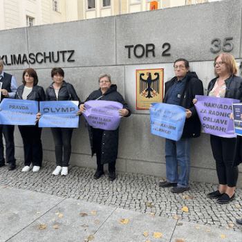 #yourturnOLYMP: Aktionen in Berlin 1 Sieben Personen stehen vor einer grauen Mauer. Sie halten blaue und lilafarbene Plakate in den Händen.