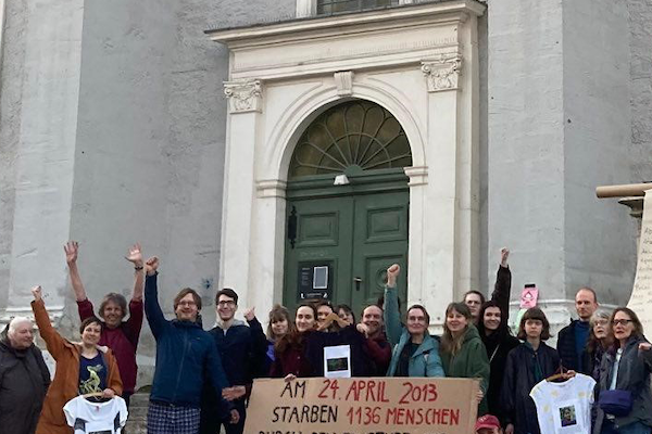 Eine Gruppe Menschen; einige halten Fäuste nach oben.