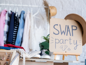 Aktiv werden! 15 Auf einem Papp-Schild steht Swap-Party. Im Hintergrund sind Kleider zu sehen