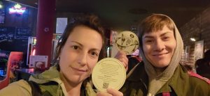 Aktiv werden! 22 Zwei Frauen halten einen Bierdeckel in die Kamera.